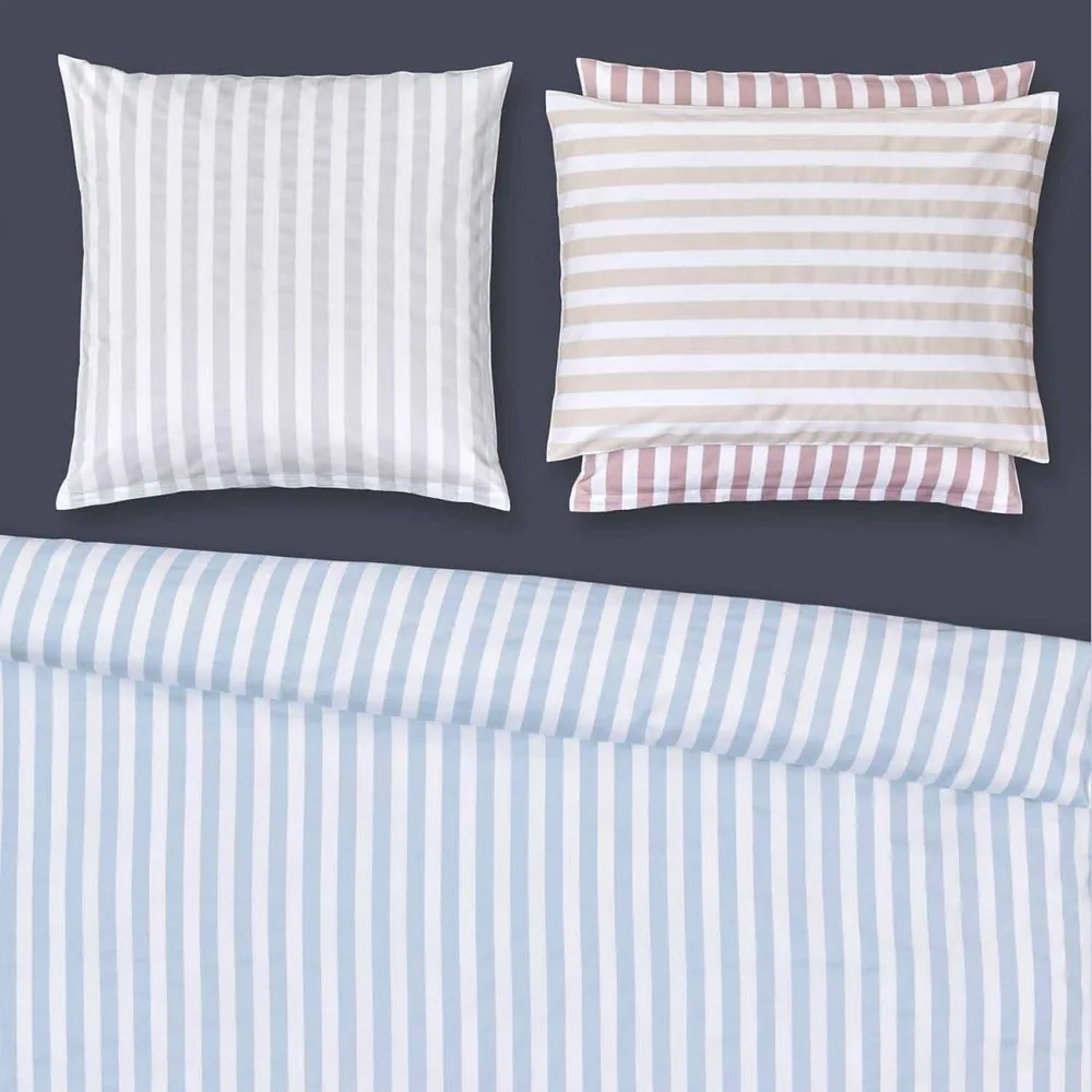 Un lit avec des draps et des oreillers à rayures