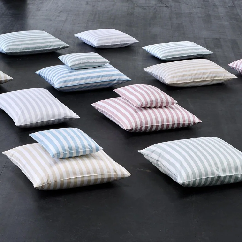 Un tas de coussins à rayures est posé sur le sol