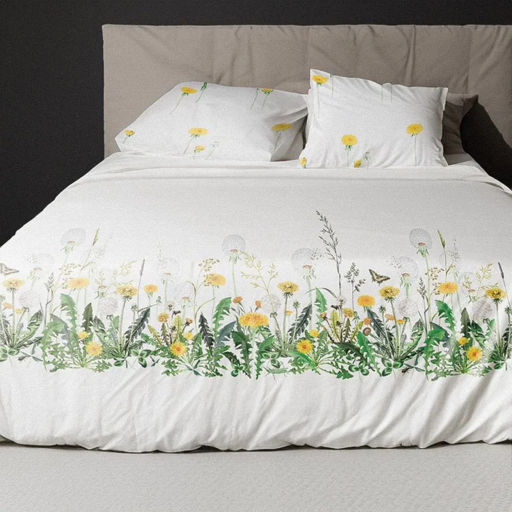 Un lit avec une couette blanche ornée de fleurs jaunes