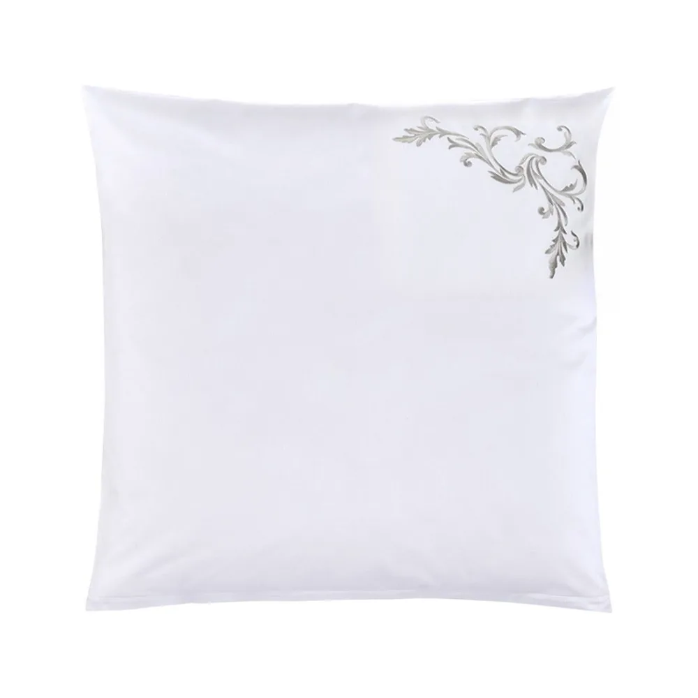 A white pillow is sitting on a white surface.