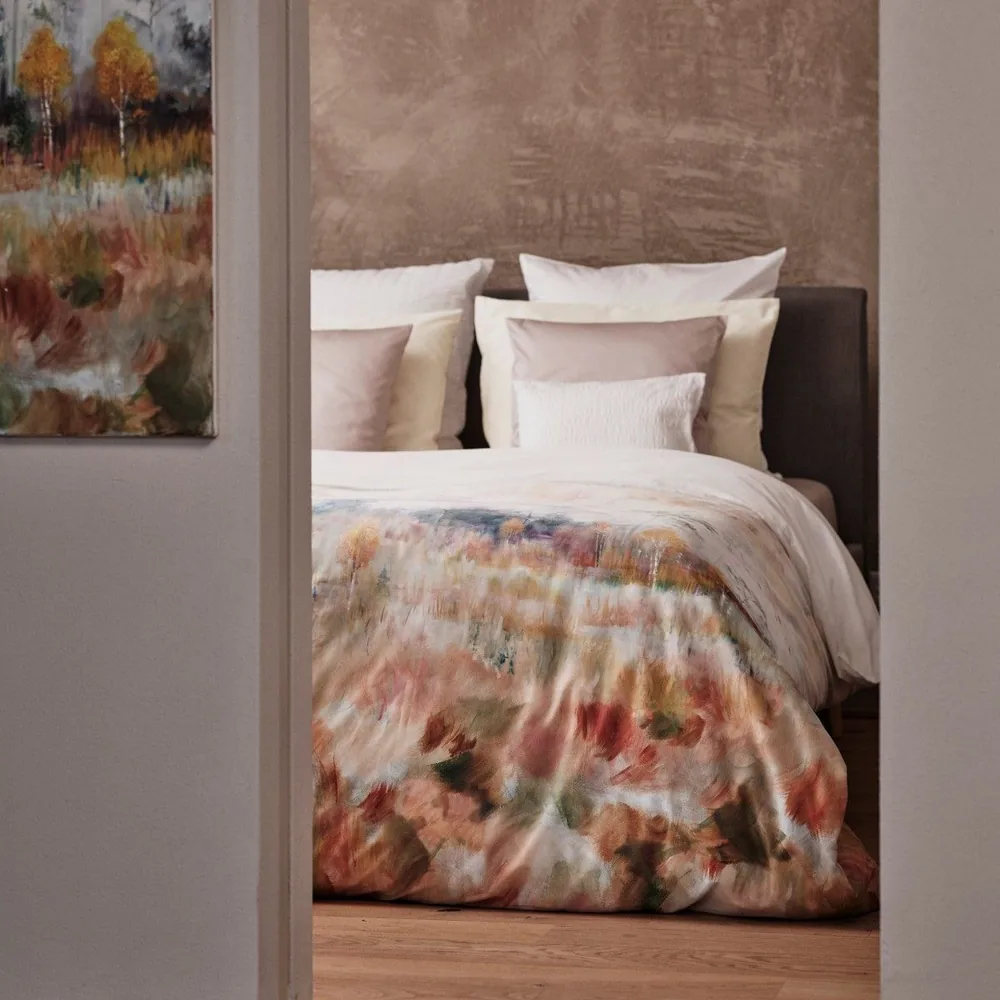 A close up of a bed with pillows on it